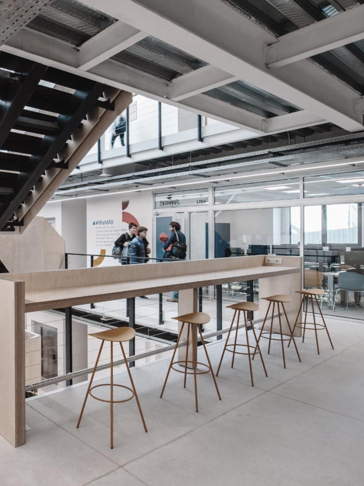Bedrijfsrestaurant met lange tafel en barkrukken in een modern kantoor